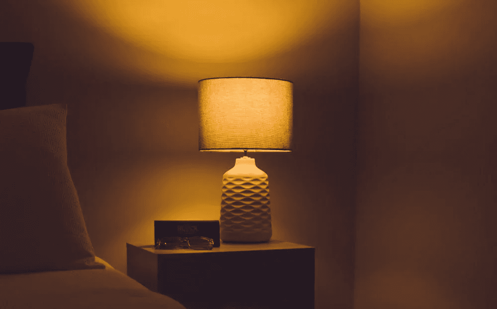Warm-toned bedside lamp creating cozy ambient lighting in bedroom
